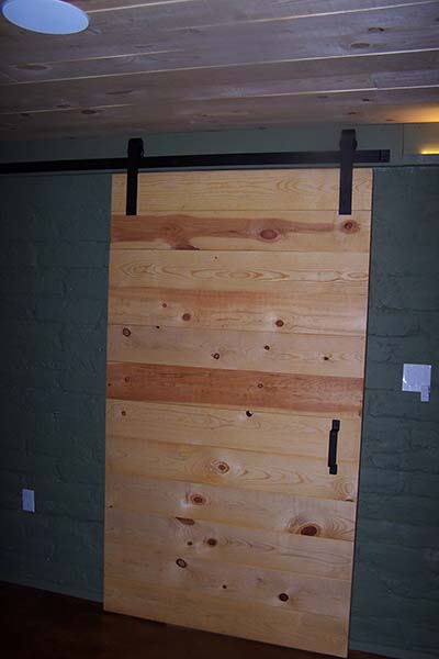 barn door leading from man cave to exercise room